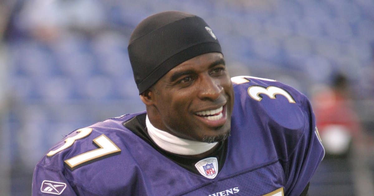 Baltimore Ravens cornerback Deion Sanders, left, returns an