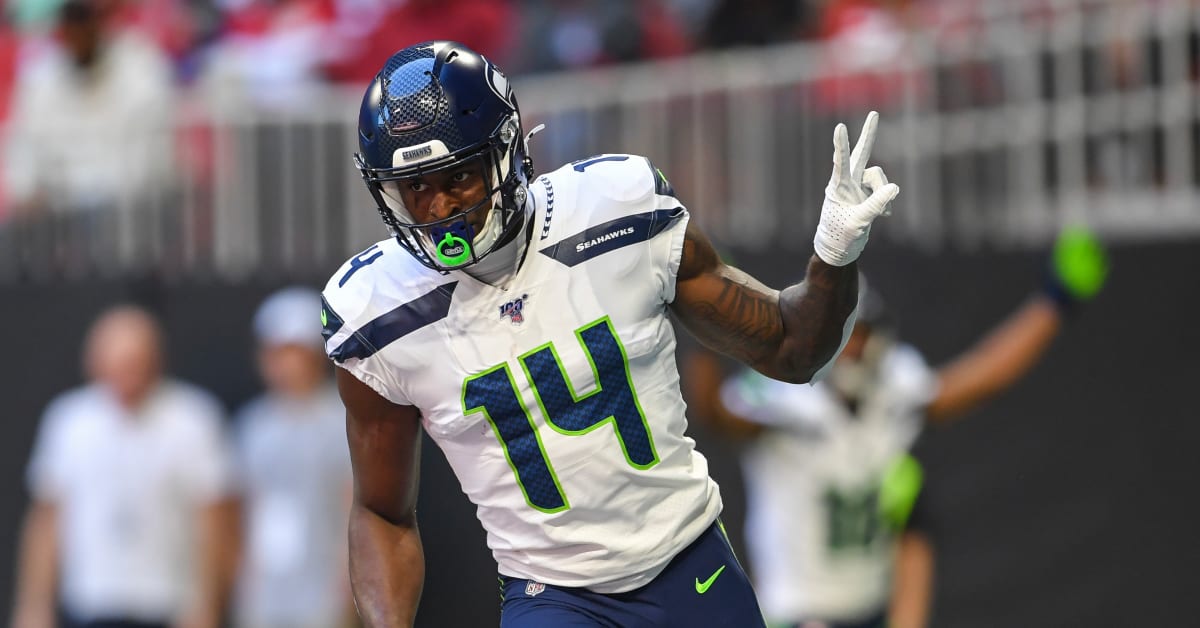 Seattle Seahawks' DK Metcalf (14) tries to scramble away from Chicago Bears'  Artie Burns during the second half of an NFL football game, Sunday, Dec.  26, 2021, in Seattle. (AP Photo/Stephen Brashear