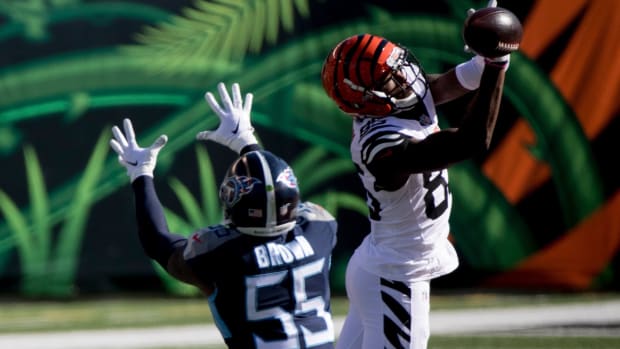 The ball goes through the hands of Cincinnati Bengals wide receiver Tee Higgins (85) as Tennessee Titans inside linebacker Jayon Brown (55) attempts to intercept it in the first quarter of the NFL game between Cincinnati Bengals and Tennessee Titans on Sunday, Nov. 1, 2020, in Cincinnati.