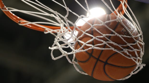 A close-up image of a basketball going through a net.