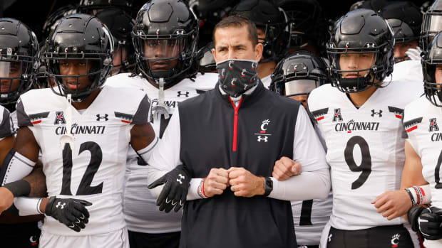 Nov 21, 2020; Orlando, Florida, USA; Cincinnati Bearcats head coach Luke Fickell (middle) and quarterback Desmond Ridder (9) and cornerback Ahmad Gardner (12) lead the team onto the field before the game against the UCF Knights at the Bounce House. Mandatory Credit: Reinhold Matay-USA TODAY Sports