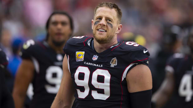 Cardinals defensive lineman J.J. Watt looks on without a helmet during a game.