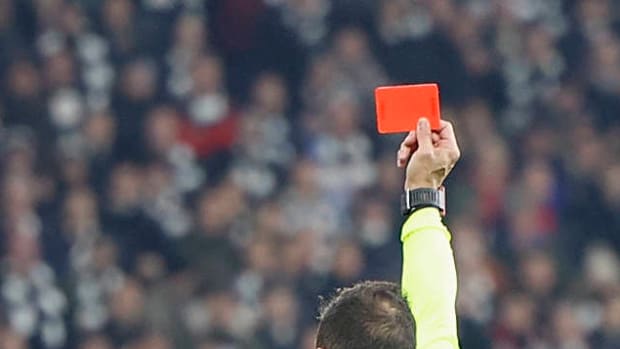 Mano de árbitro sostiene tarjeta roja