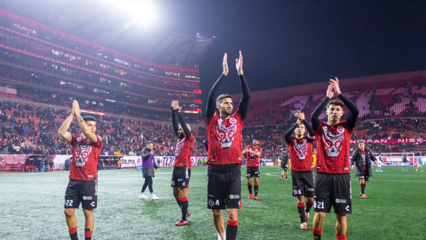 Jugadores de Xolos aplauden después de ganar partido.