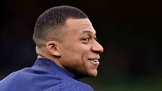 Kylian Mbappé de perfil sonriendo