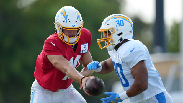 Aug 1, 2022; Costa Mesa, CA, USA; Los Angeles Chargers quarterback Justin Herbert (10) hands the ball off to running back Austin Ekeler (30) during training camp at the Jack Hammett Sports Complex.
