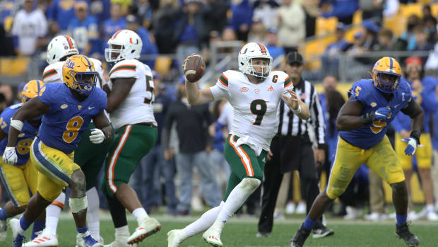 Miami Hurricanes quarterback Tyler Van Dyke (9) scrambles with the ball as Pittsburgh Panthers defensive lineman Calijah Kancey (8) and defensive lineman Deslin Alexandre (5) chase during the fourth quarter at Heinz Field. Miami won 38-34.