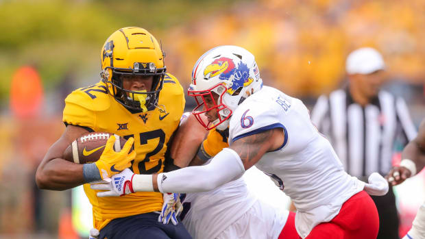 Sep 10, 2022; Morgantown, West Virginia, USA; West Virginia Mountaineers running back CJ Donaldson (12) runs the ball and is tackled by Kansas Jayhawks linebacker Taiwan Berryhill (6) during the first quarter at Mountaineer Field at Milan Puskar Stadium. Mandatory Credit: Ben Queen-USA TODAY Sports