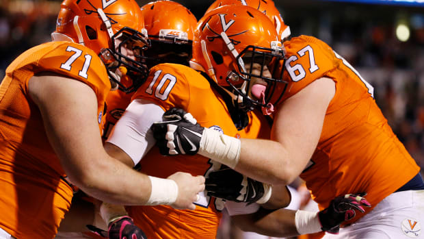 Virginia Cavaliers running back Jordan Ellis (10) celebrates with teammates after scoring the game winning touchdown against the Syracuse Orange in the third overtime at Scott Stadium. The Cavaliers won 44-38 in triple overtime.