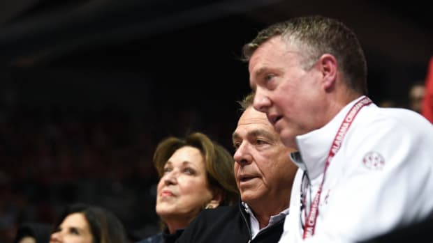 Alabama football coach Nick Saban and athletic director Greg Byrne watch a basketball game in 2023.