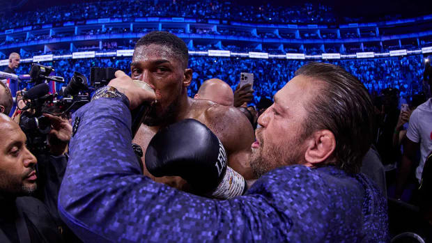 UFC megastar Conor McGregor gives Anthony Joshua a swig of alcohol after his victory over Robert Helenius.