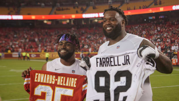Chiefs RB Clyde Edwards-Helaire and Raiders DT Neil Farrell Jr. pose after a game.