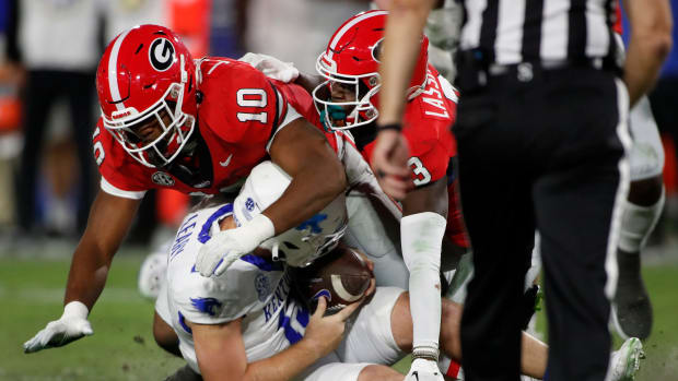 Georgia linebacker Jamon Dumas-Johnson (10) and Georgia defensive back Kamari Lassiter (3) sack Kentucky quarterback Devin Leary (13) during the first half of a NCAA college football game in Athens, Ga., on Saturday, Oct. 7, 2023.