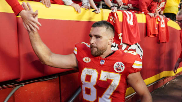 Chiefs tight end Travis Kelce high fives fans after a game.