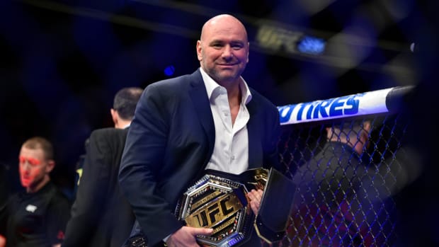 UFC CEO Dana White carrying a championship to present to the winner.