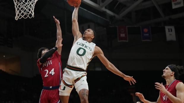 Nov 6, 2023; Coral Gables, Florida, USA; Miami (Fl) Hurricanes guard Matthew Cleveland (0) goes up for a dunk over N.J.I.T Highlanders guard Mekhi Gray (24) in the first half at Watsco Center. Mandatory Credit: Jim Rassol-USA TODAY Sports