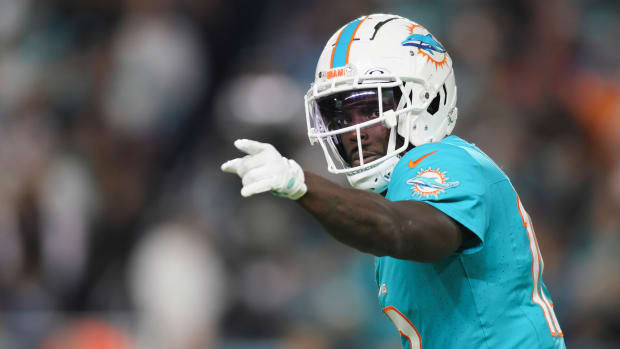 Tyreek Hill points with his left hand while looking to the side in his helmet