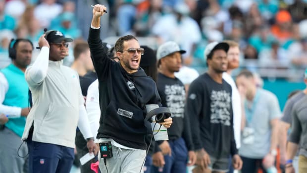 Mike McDaniel throws his fist up in celebration on the sideline