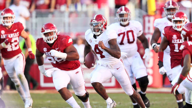 Alabama Crimson Tide quarterback Jalen Milroe (4) rushes in the fourth quarter as Arkansas Razorbacks defensive lineman Terry Hampton pursues at Donald W. Reynolds Razorback Stadium. Alabama won 49-26