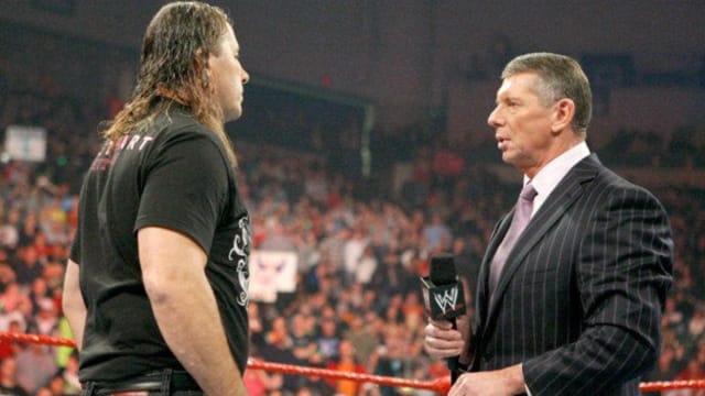 Bret Hart stares down Vince McMahon during an in-ring segment on WWE Raw.