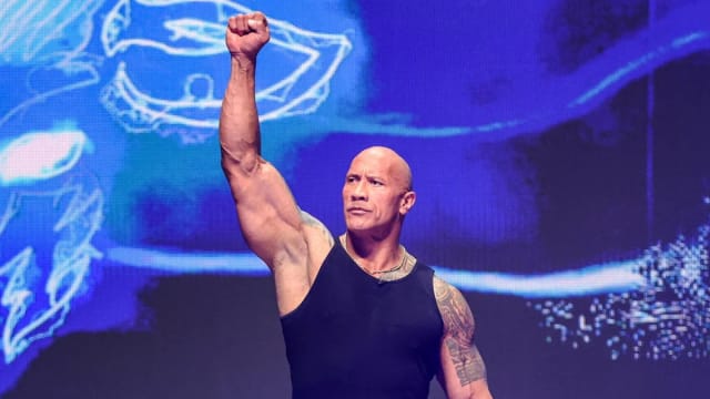 The Rock raises his arm during the WrestleMania 40 Kickoff media event in Las Vegas.