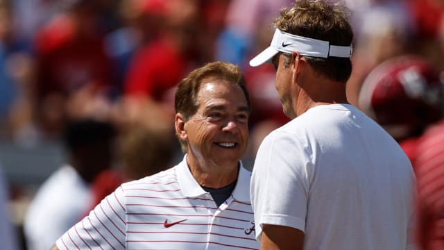 Alabama Crimson Tide head coach Nick Saban, left, talks with Mississippi Rebels head coach Lane Kiffin, right, before the game at Bryant-Denny Stadium.