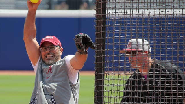 Alabama coach Patrick Murphy pitches during a practice for the Women's College World Series at USA Softball Hall of Fame Stadium in Oklahoma City, Wednesday, May 31, 2023