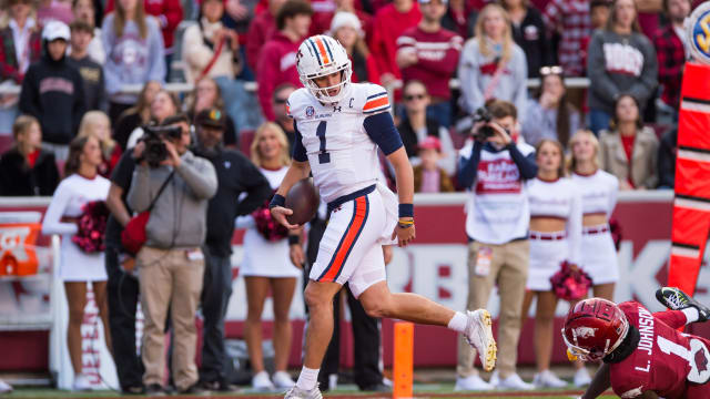 Nov 11, 2023; Fayetteville, Arkansas, USA; Auburn Tigers quarterback Payton Thorne (1) scores a touchdown and looks back at Arkansas Razorbacks defensive back Lorando Johnson (1) during the first quarter at Donald W. Reynolds Razorback Stadium. Mandatory Credit: Brett Rojo-USA TODAY Sports  