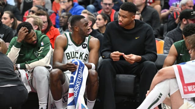 Milwaukee Bucks forward Thanasis Antetokounmpo (34) speaks with his brother, forward Giannis Antetokounmpo at the team bench 