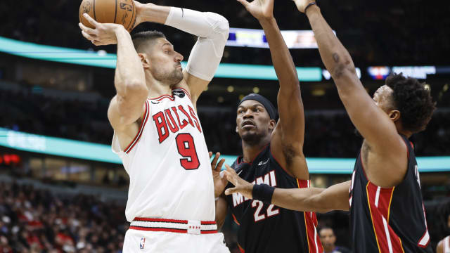 Chicago Bulls center Nikola Vucevic (9) looks to pass the ball against Miami Heat forward Jimmy Butler (22) and guard Kyle Lowry (7) during the first half at United Center.