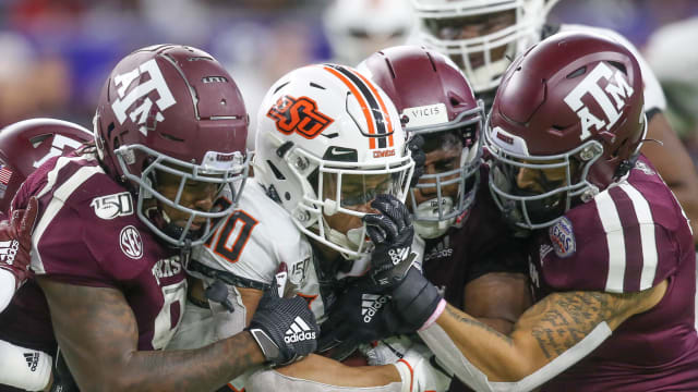 Oklahoma State Cowboys running back Chuba Hubbard (30) is face masked by Texas A&M Aggies defensive back Devin Morris (7) in the fourth quarter at NRG Stadium.