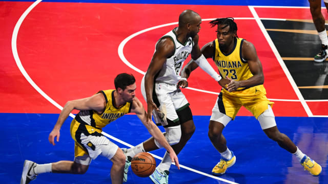 Indiana Pacers guard T.J. McConnell (9) steals the ball as forward Aaron Nesmith (23) defends Milwaukee Bucks forward Khris Middleton (22) 