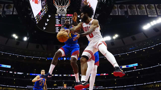 Chicago Bulls guard Coby White (0) looks to pass the ball around Denver Nuggets center DeAndre Jordan (6) during the second half at United Center