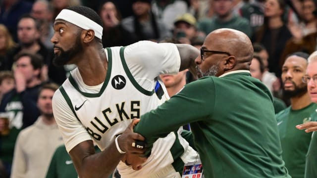 Milwaukee Bucks forward Bobby Portis (9) is restrained by a coach 