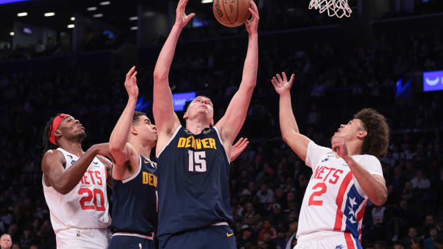 Denver Nuggets center Nikola Jokic (15) rebounds against Brooklyn Nets forward Cameron Johnson (2) and center Day'Ron Sharpe (20) 