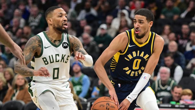 Indiana Pacers guard Tyrese Haliburton (0) passes the ball away from Milwaukee Bucks guard Damian Lillard (0) 