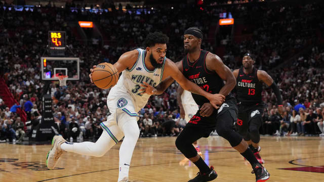 Dec 18, 2023; Miami, Florida, USA; Minnesota Timberwolves center Karl-Anthony Towns (32) drives the ball around Miami Heat forward Jimmy Butler (22) during the second half at Kaseya Center.