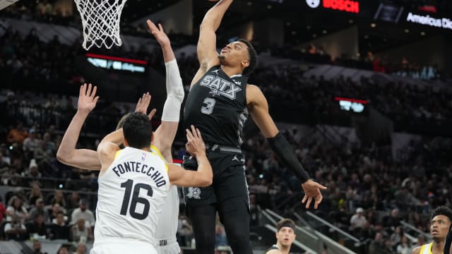 Dec 26, 2023; San Antonio, Texas, USA; San Antonio Spurs forward Keldon Johnson (3) dunks over Utah Jazz forward Simone Fontecchio (16) in the second half at Frost Bank Center.