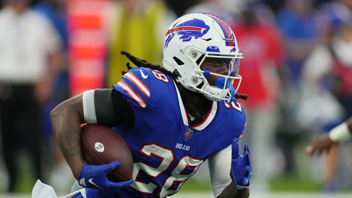 Buffalo Bills RB James Cook attempts to paint team logo with other