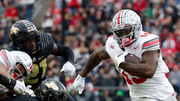 Ohio State running back Chip Trayanum (No. 19) evades two Purdue defensive lineman at Ross-Ade Stadium 