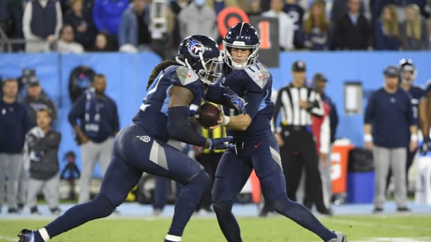 Tennessee Titans running back Derrick Henry (22) takes a handoff from  quarterback Ryan Tannehill (17) during