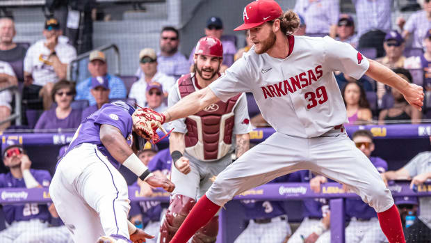 Arkansas pitcher Hunter Hollan applies the tag at the plate in a Game 1 win against LSU in Baton Rouge.