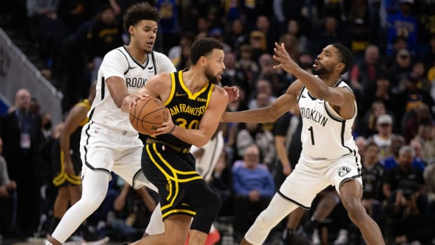 Brooklyn Nets forward Cameron Johnson (2) and guard Mikal Bridges (1) double team Golden State Warriors guard Stephen Curry (30) 
