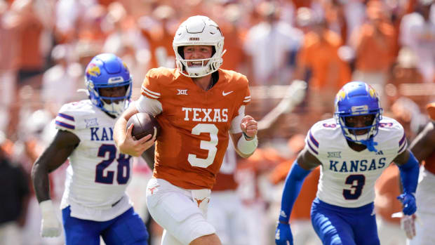 Texas Longhorns quarterback Quinn Ewers runs past Kansas Jayhawks linebacker, left, and cornerback Mello Dotson for a touchdown in the first quarter at Royal-Memorial Stadium.