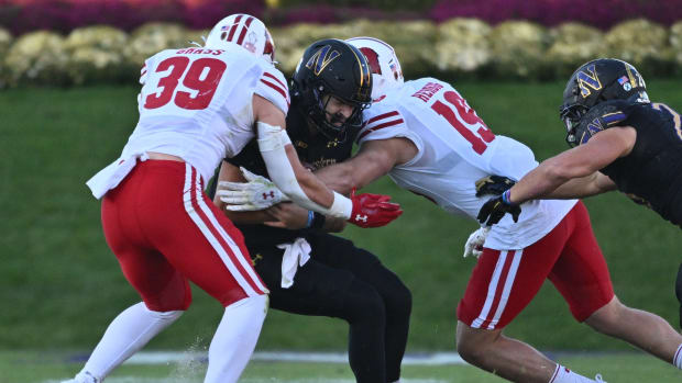 Wisconsin linebacker Tate Grass and Nick Herbig combining for a tackle against Northwestern.