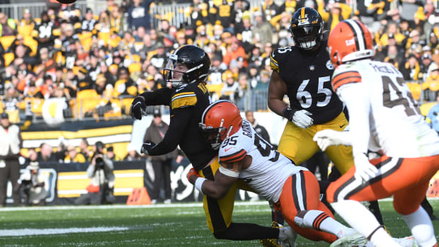 Jan 8, 2023; Pittsburgh, Pennsylvania, USA; Pittsburgh Steelers quarterback Kenny Pickett (8) releases the ball as he is hit by Cleveland Browns dfensive end Myles Garrett (95) during the second quarter at Acrisure Stadium.