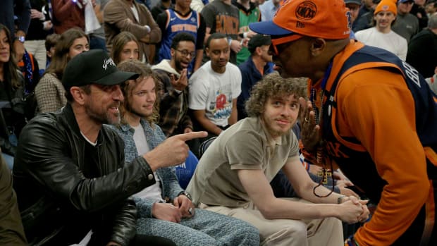 Aaron Rodgers and Jack Harlow speak with Spike Lee during a Knicks game.