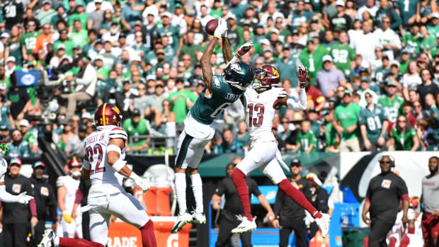 Philadelphia Eagles receiver DeVonta Smith (6) makes a leaping catch over Washington Commanders cornerback Emmanuel Forbes (13).