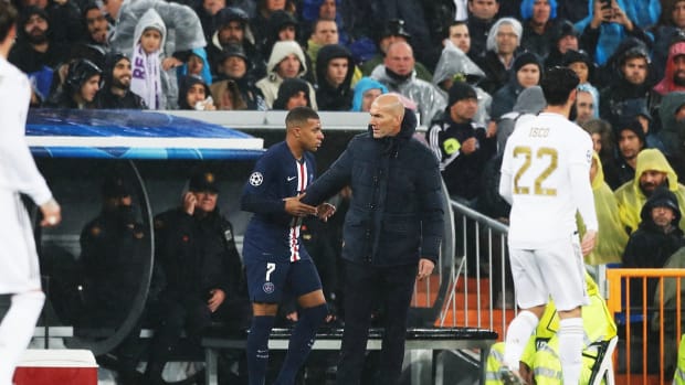 Kylian Mbappe (no.7) and Zinedine Zidane pictured shaking hands during a UEFA Champions League game between Real Madrid and PSG in November 2019