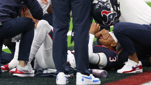 Trainers work on an injured Houston Texans wide receiver Tank Dell as he injured himself on a touchdown play against the Denver Broncos at NRG Stadium.